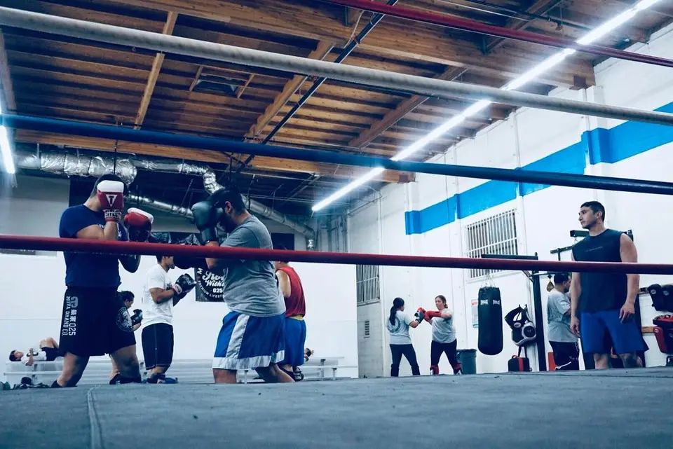 Muay Thai Kickboxing students working on pads in the training area